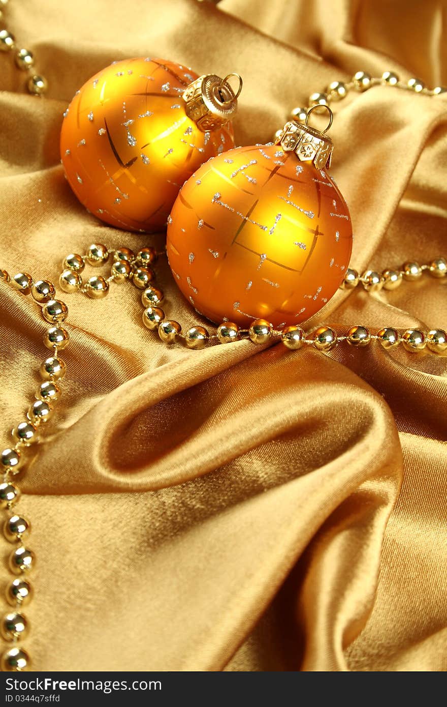 On gold fabric are gold ornaments and Christmas balls of yellow. Background. On gold fabric are gold ornaments and Christmas balls of yellow. Background