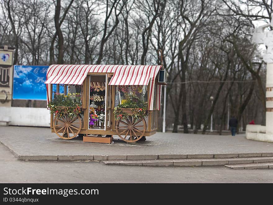 Shop with flowers in a coach in the city. Bokeh background. Cloudy day. Shop with flowers in a coach in the city. Bokeh background. Cloudy day