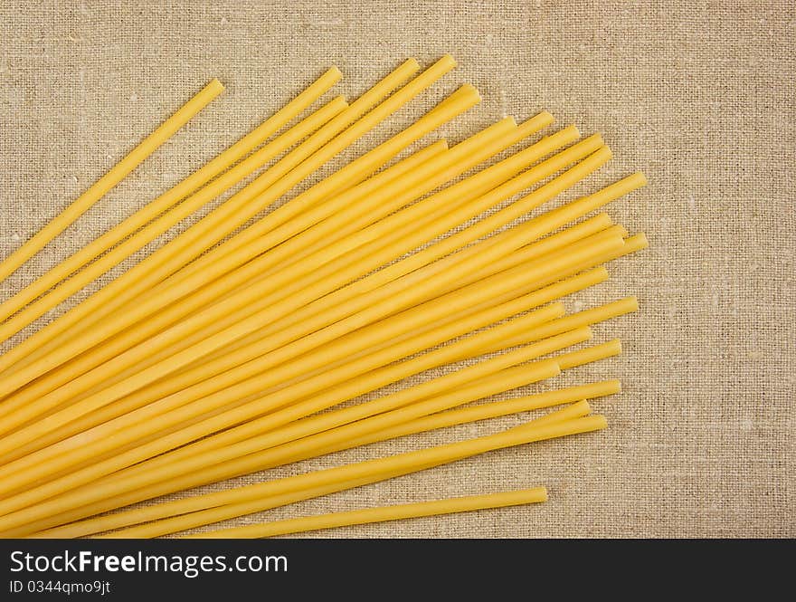 Raw spaghetti on the burlap background