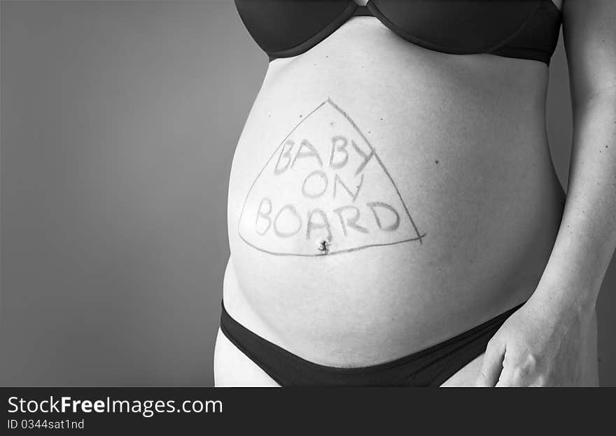 Expectant mother with writing baby on board