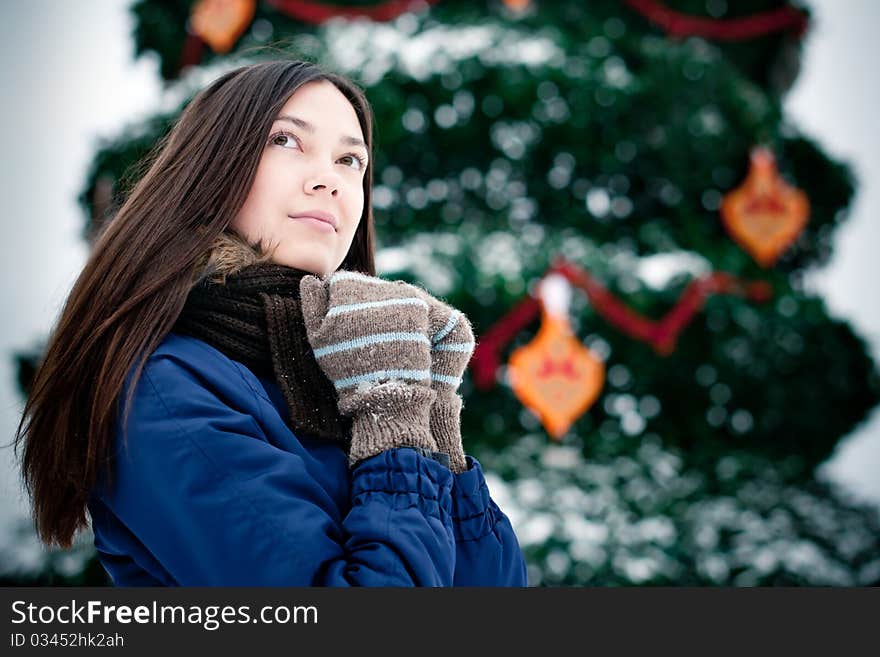 Attractive brunette young woman near to the fir-tree