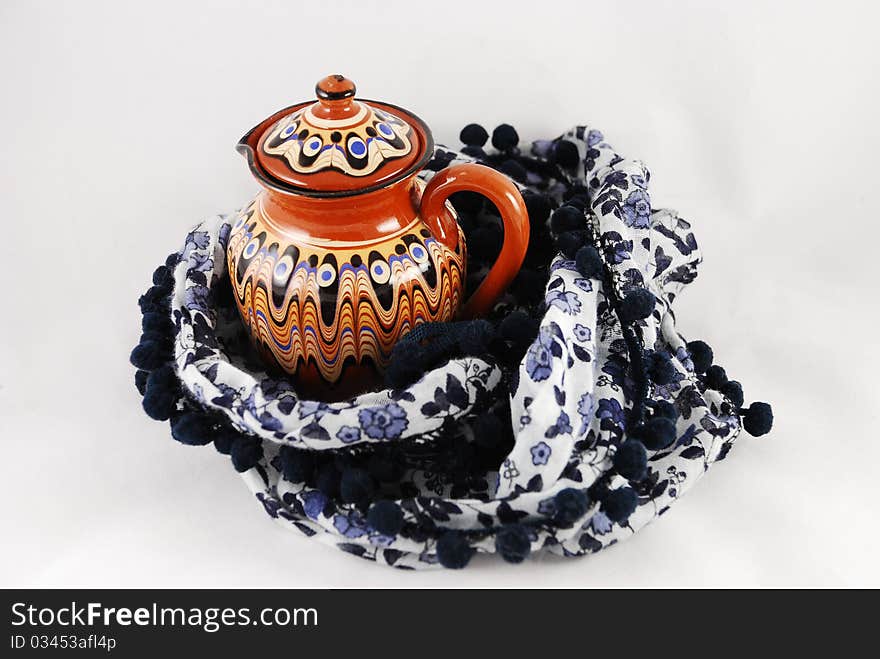 A jug and a shawl on white background