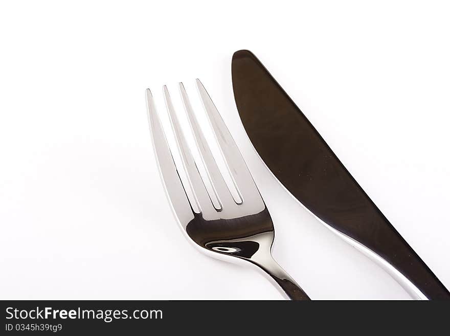 Knife and fork on a white background - tableware.