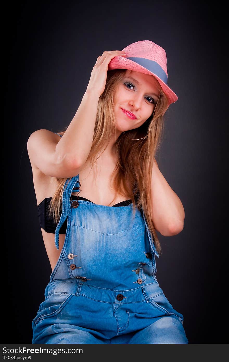 Pretty girl in pink hat and jeans overalls