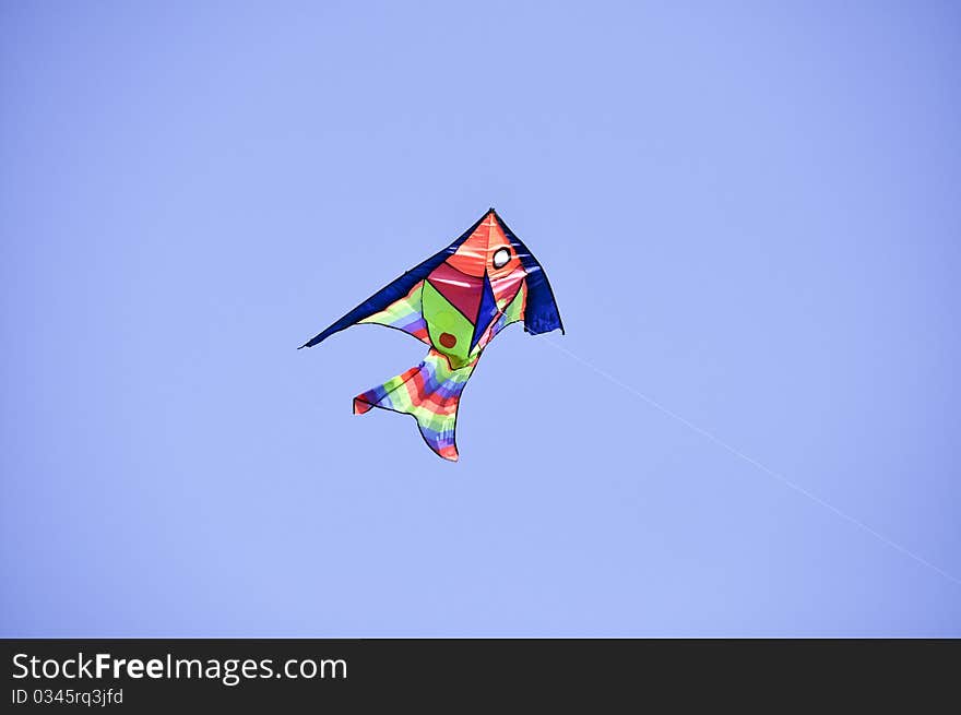 Kite on a string on a background of blue sky