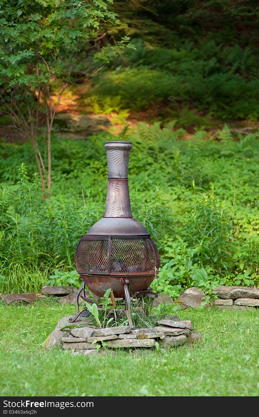 Rustic metal chiminea in the summer backyard