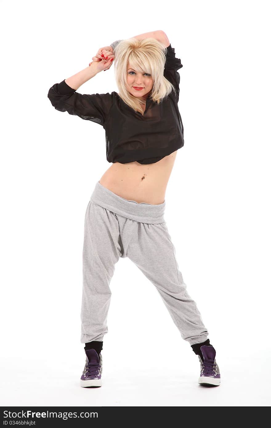 Beautiful young blonde female street dancer, wearing black and grey outfit and trainers, standing on a white backdrop. Beautiful young blonde female street dancer, wearing black and grey outfit and trainers, standing on a white backdrop.