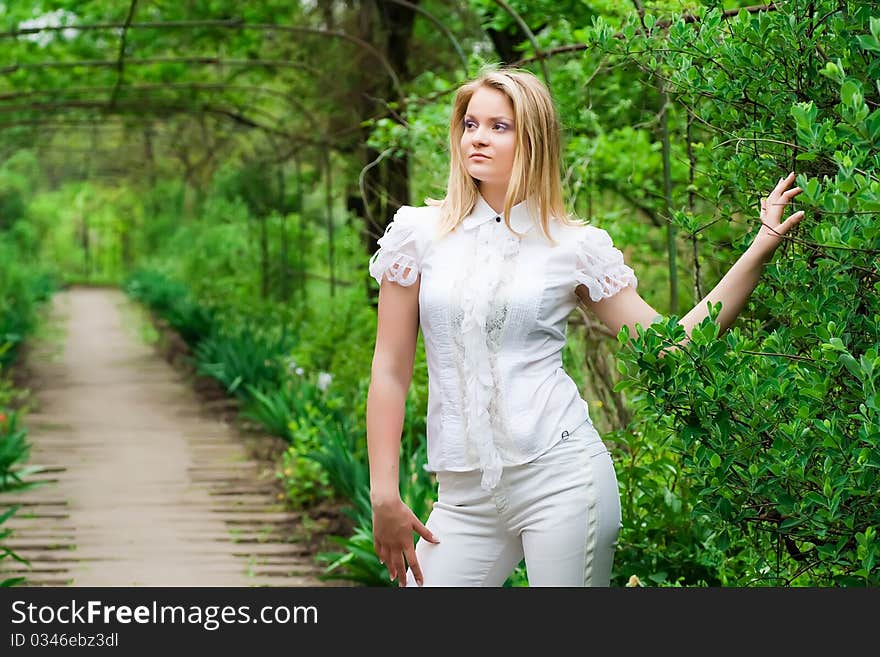 Girl in white standing in a beautiful bright green alley