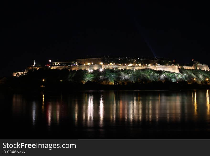 Petrovaradin Fortress at night with reflection in Danube river during EXIT Music festival