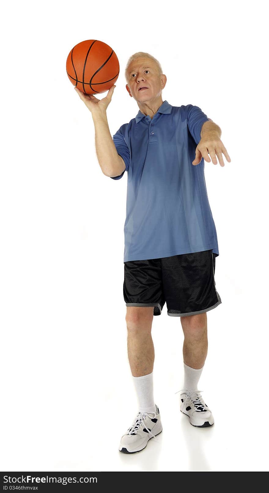 A senior man aiming his basketball for a one-handed shot. Isolated on white. A senior man aiming his basketball for a one-handed shot. Isolated on white.