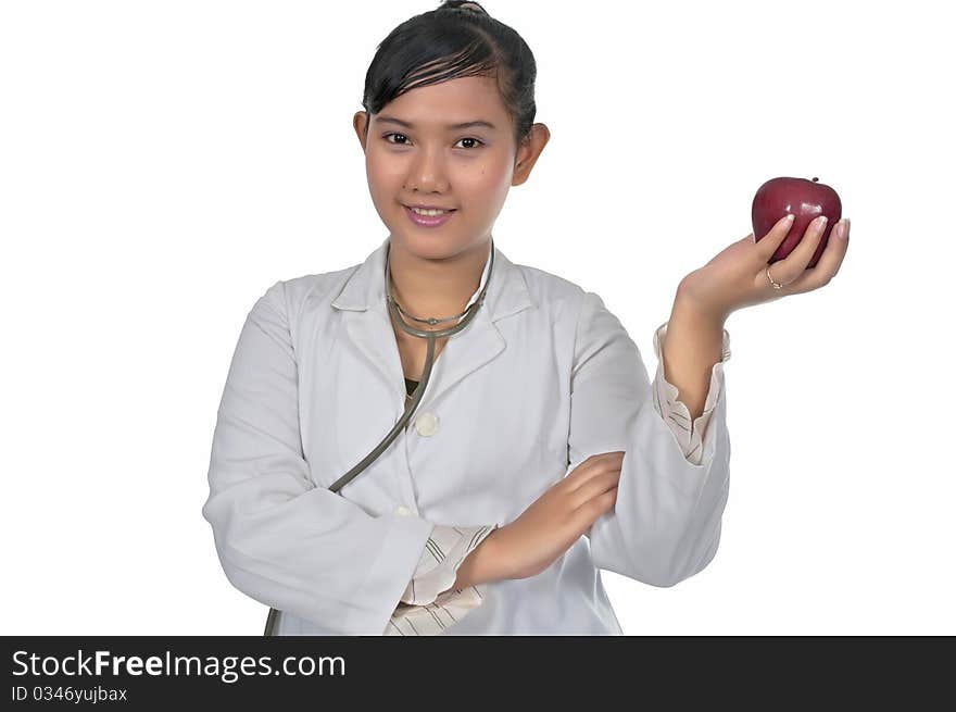 Beautiful young doctor wearing white coat holding red apple isolated over white background. Beautiful young doctor wearing white coat holding red apple isolated over white background