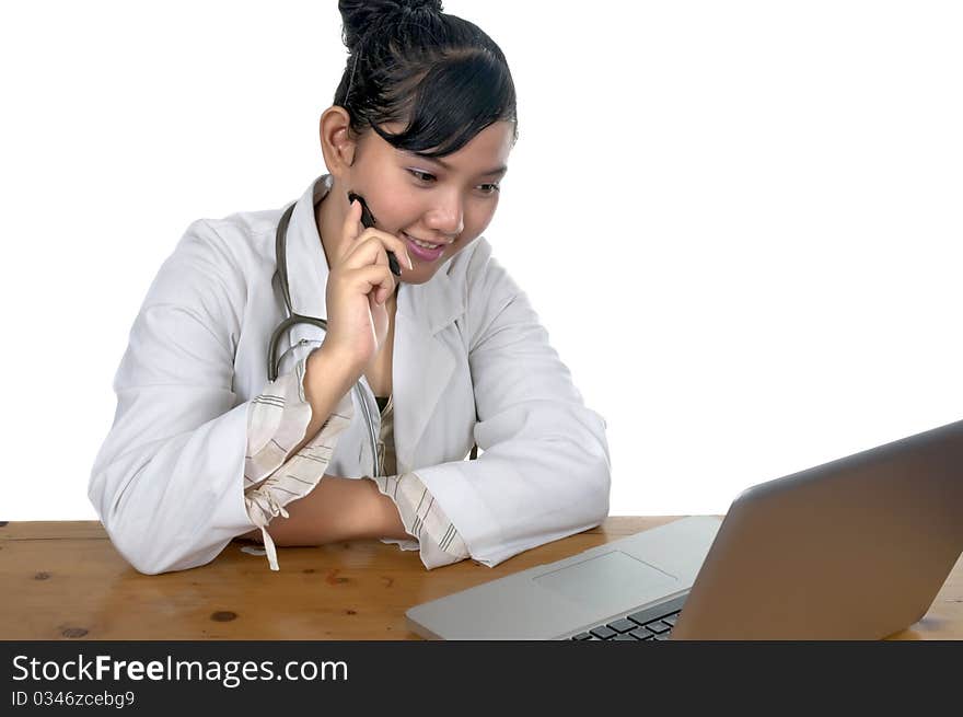 Beautiful young doctor working in front of laptop isolated over white background. Beautiful young doctor working in front of laptop isolated over white background