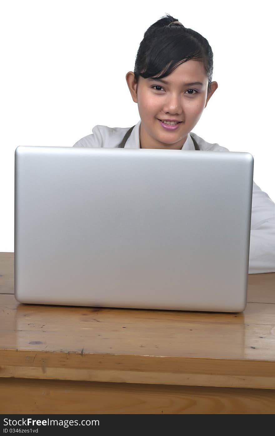 Beautiful young doctor working in front of laptop isolated over white background. Beautiful young doctor working in front of laptop isolated over white background