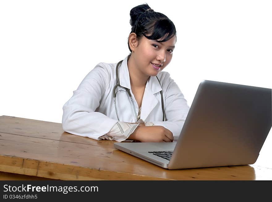 Beautiful young doctor working in front of laptop isolated over white background. Beautiful young doctor working in front of laptop isolated over white background