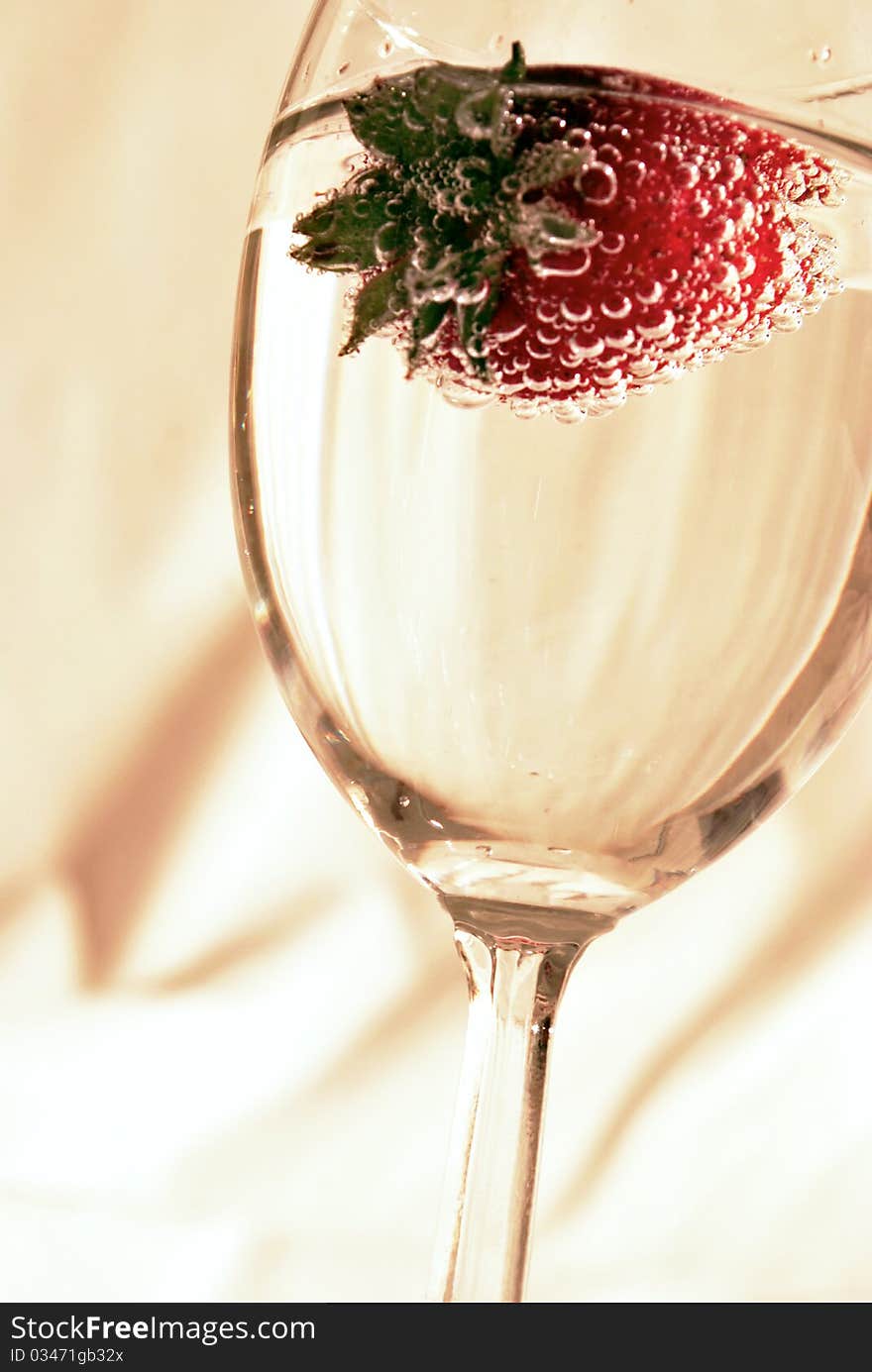 A strawberry in a glass of wine. A strawberry in a glass of wine