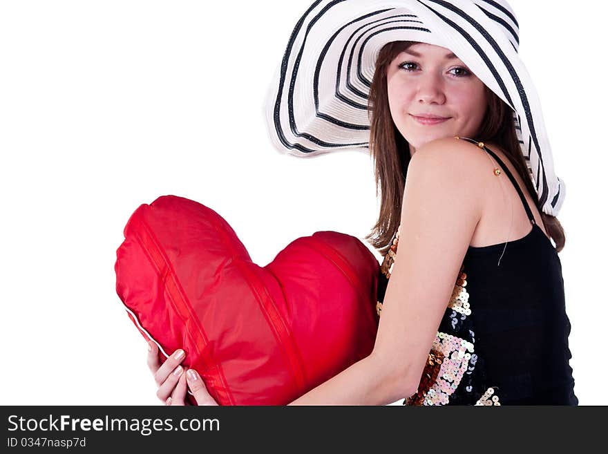 Beautiful young girl sitting on a bar chair with red heart pillow isolated on white