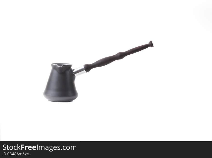 Coffee maker from dark metal with the long wooden handle of dark color on a white background. Coffee maker from dark metal with the long wooden handle of dark color on a white background