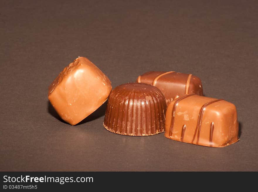 Four chocolates on a black background.