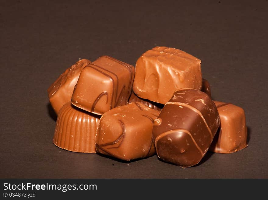 A pile of chocolates on a black background.