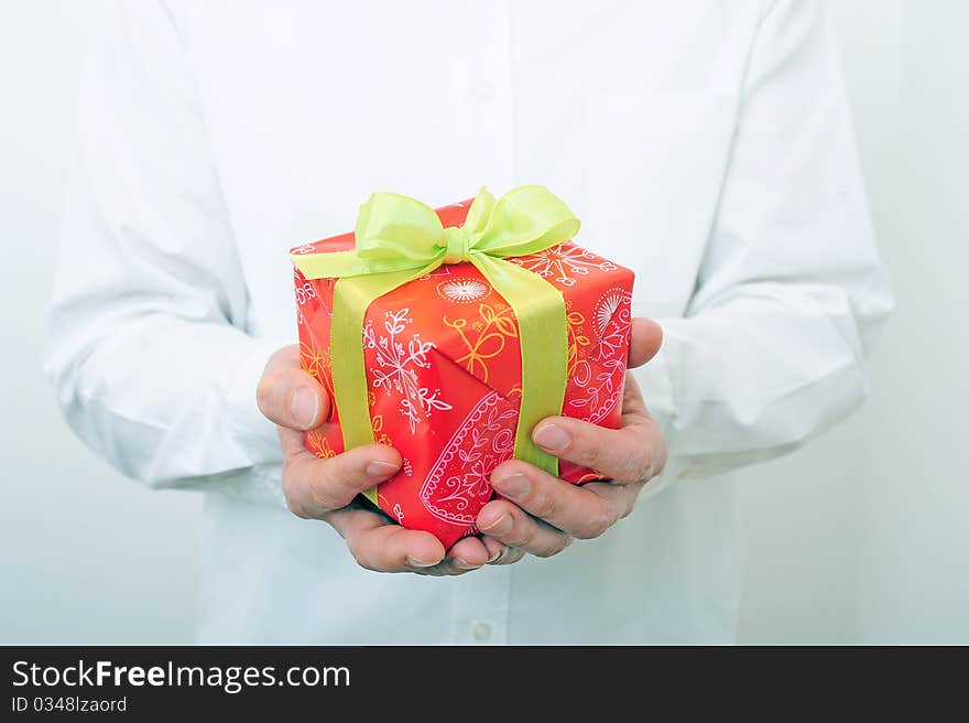 Man in white shirt is holding a present. Man in white shirt is holding a present