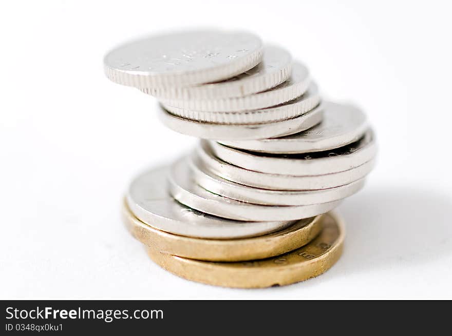 Detail shot of silver and golden coins isolated on white background. Detail shot of silver and golden coins isolated on white background.