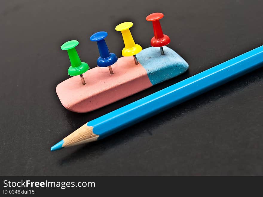 The Varicoloured office button,lasting and pencil on black background. The Varicoloured office button,lasting and pencil on black background.