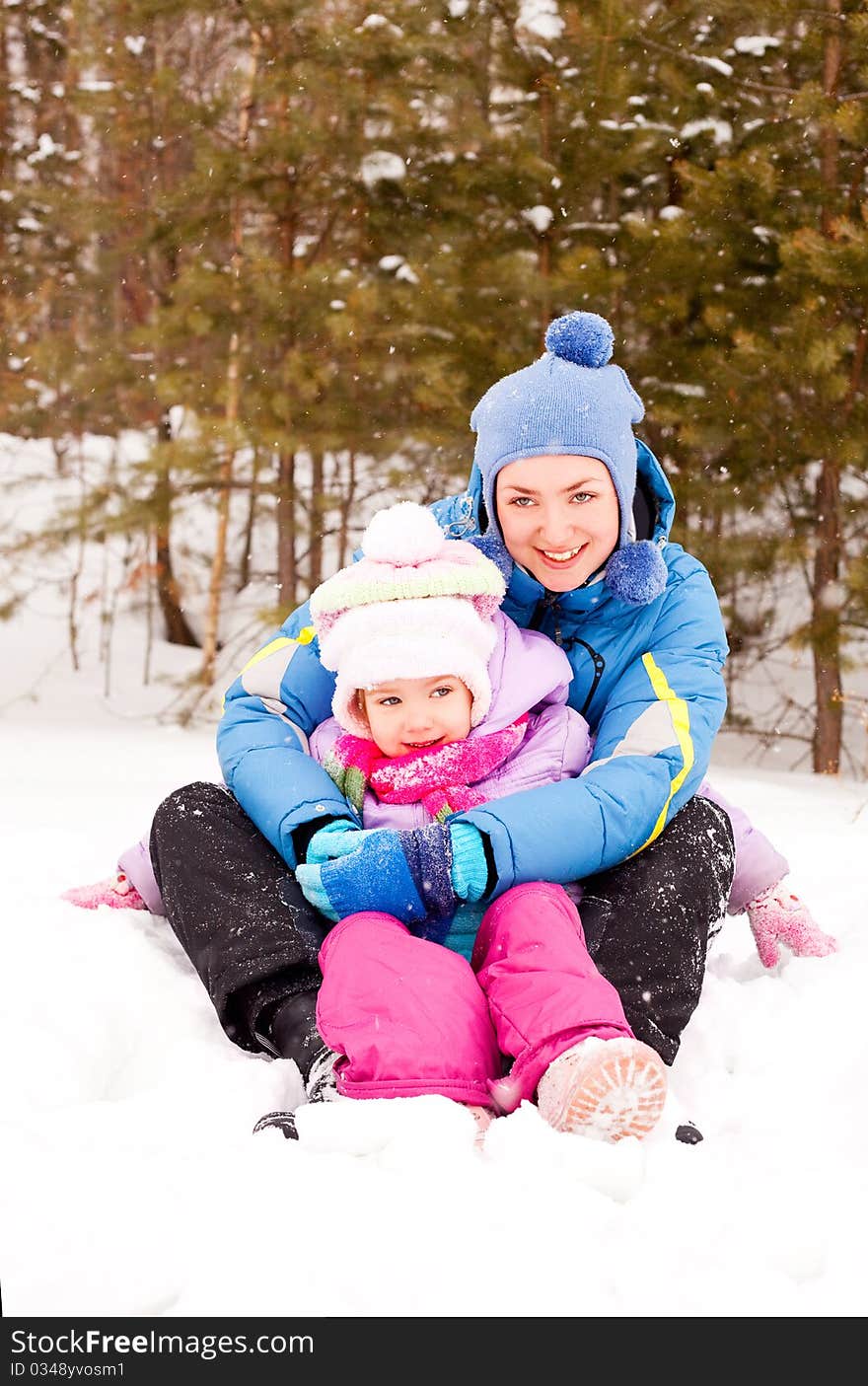 Happy family; young mother and her daughter having fun in the winter park. Happy family; young mother and her daughter having fun in the winter park