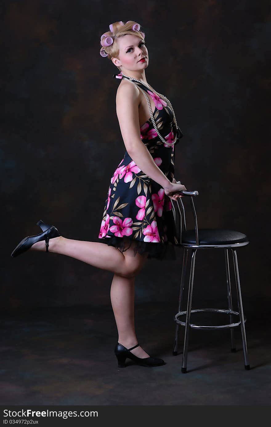 Photograph showing retro style 50s female posing with stool. Photograph showing retro style 50s female posing with stool