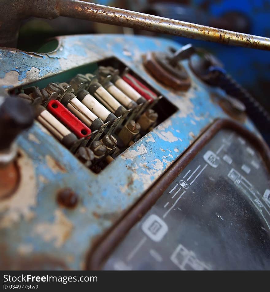 Old tractor dashboard with a key in the ignition and fuse panel.