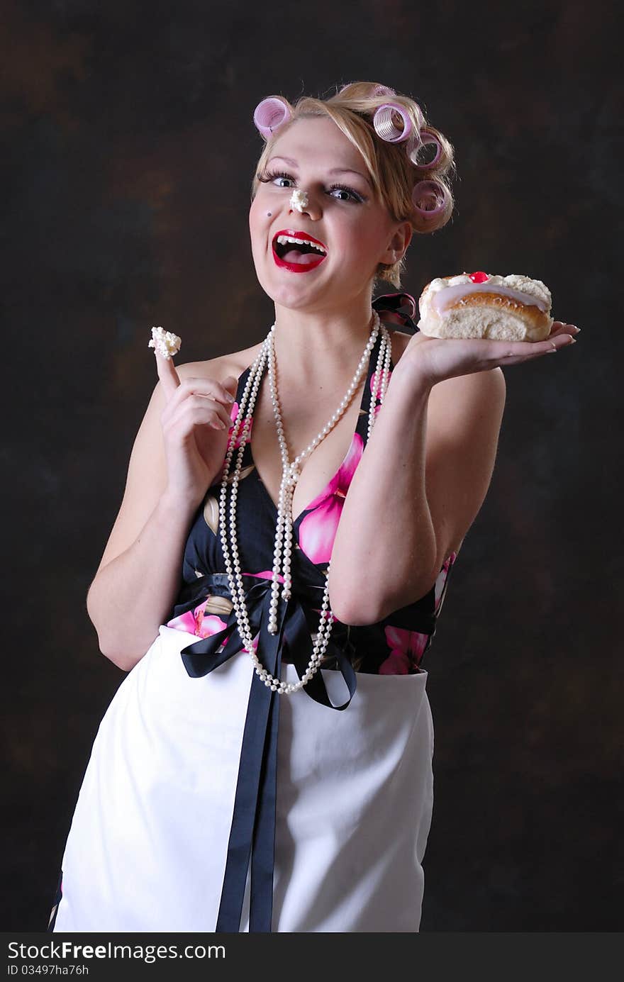 Photograph showing retro style 50s female posing against black with cream cake. Photograph showing retro style 50s female posing against black with cream cake