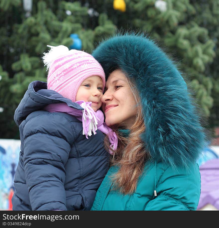 Happi Mom  and girl near a Christmas tree. Happi Mom  and girl near a Christmas tree