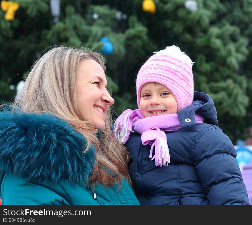 Happi Mom and girl near a Christmas tree