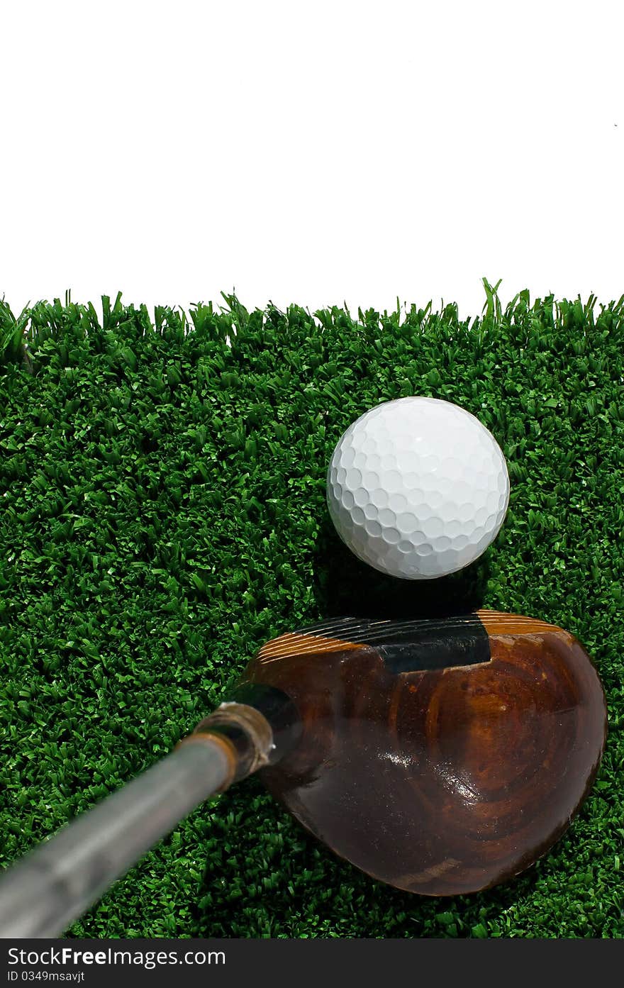 Golf ball and driver on grass