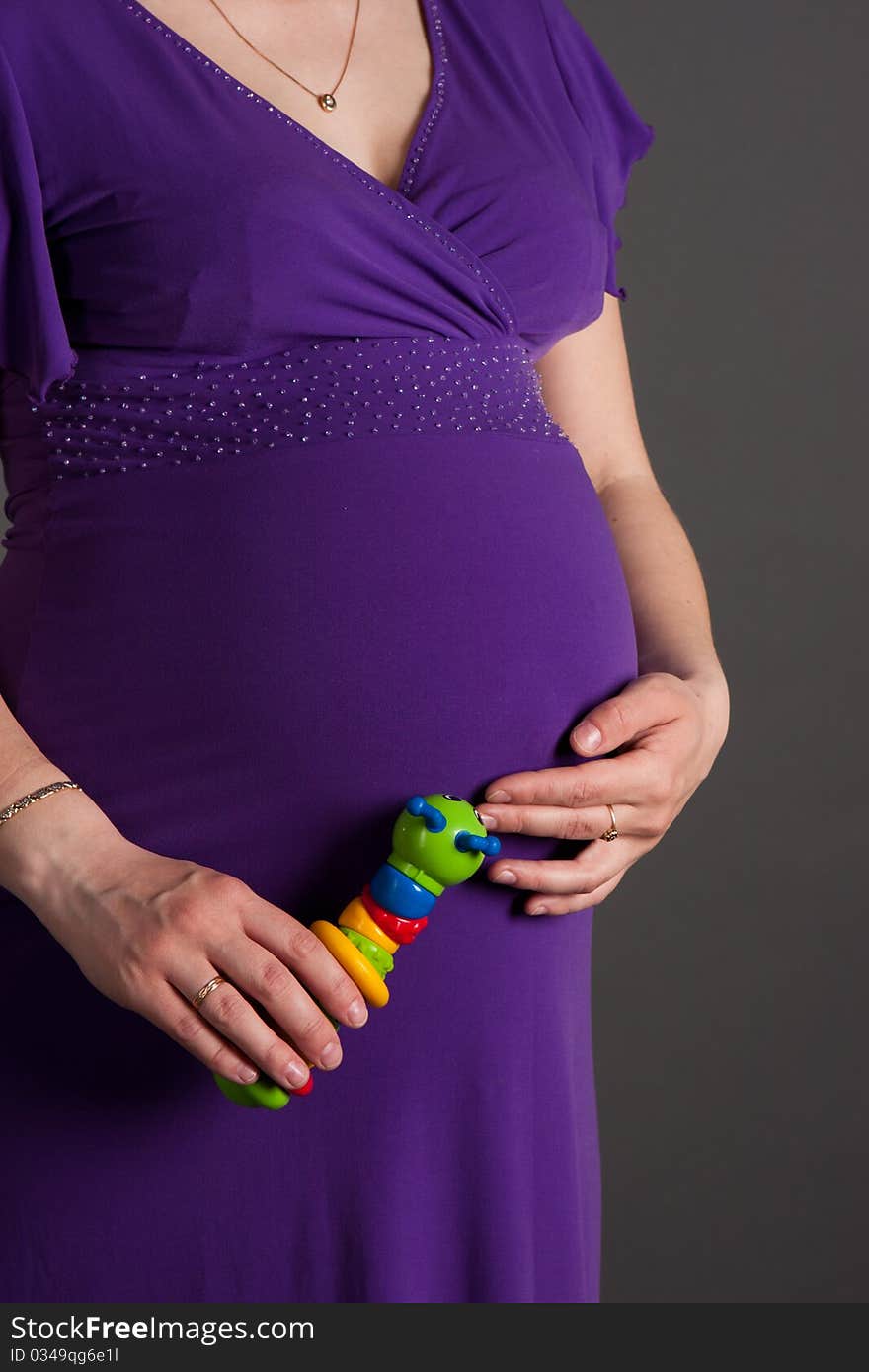 Beautiful pregnant woman staing on grey background