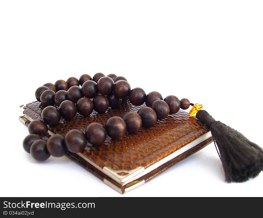 Note pad overhand wooden rosary beads on white background. Note pad overhand wooden rosary beads on white background