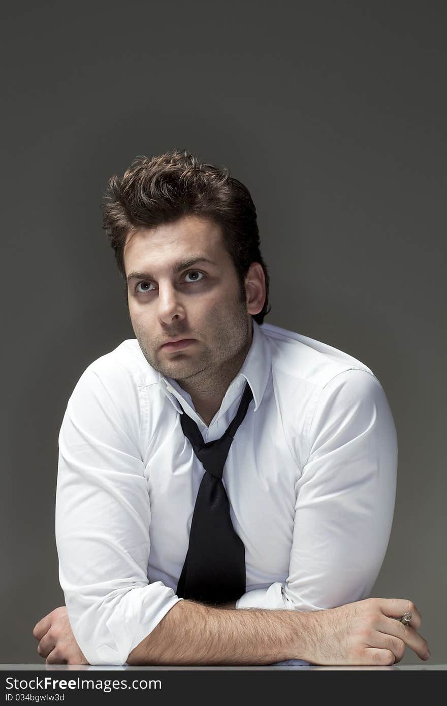 Man in white shirt looking up, thinking - isolated on gray. Man in white shirt looking up, thinking - isolated on gray