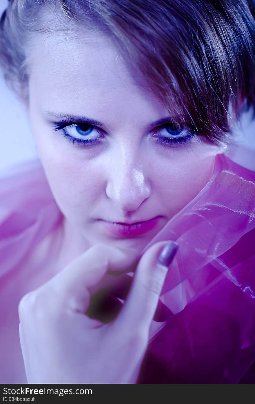 Portrait of a beautiful girl in the blue tones with a pink cloth hand of the person. Portrait of a beautiful girl in the blue tones with a pink cloth hand of the person