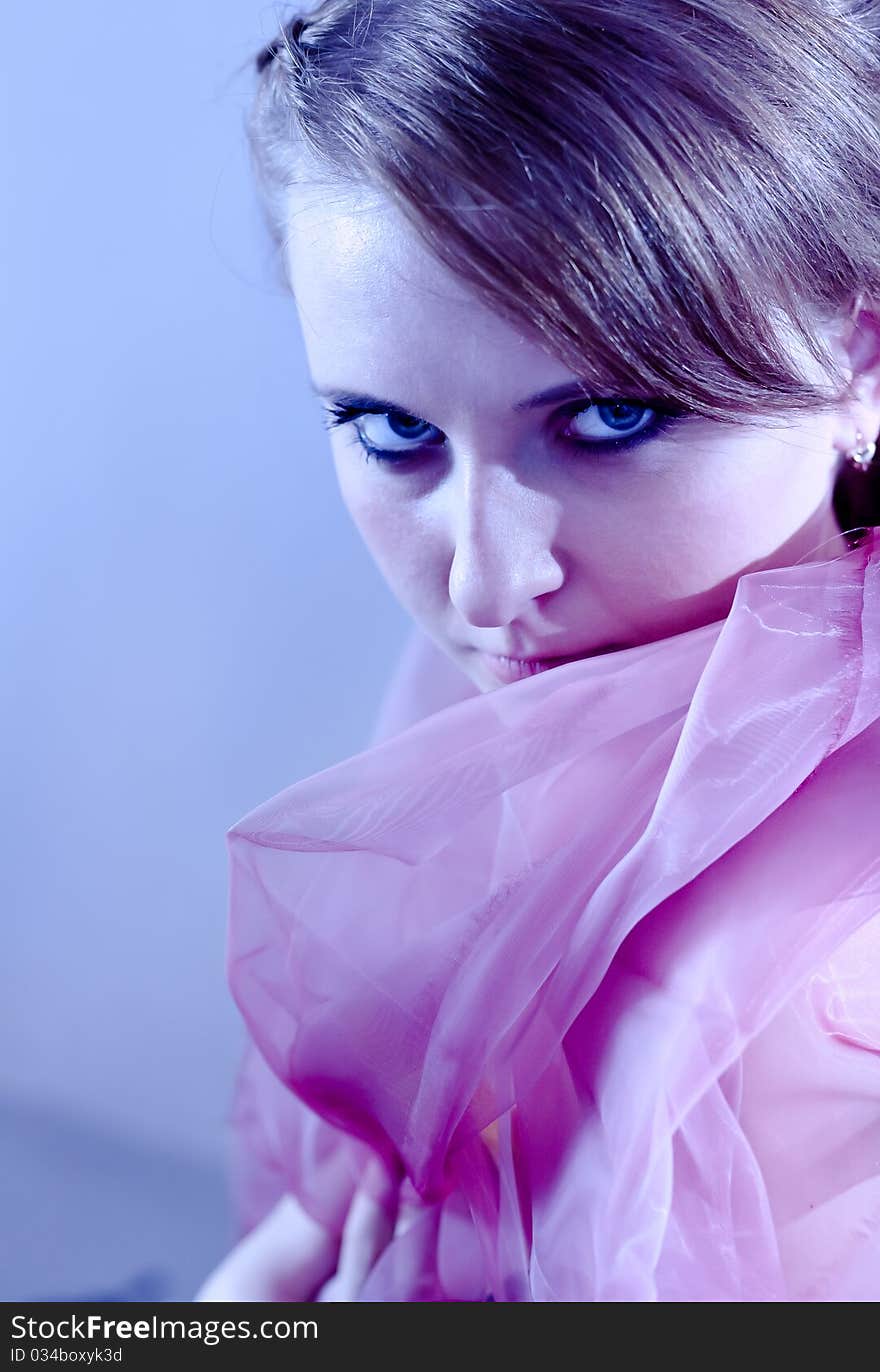 Portrait of a beautiful girl in the blue tones with a pink cloth. Portrait of a beautiful girl in the blue tones with a pink cloth