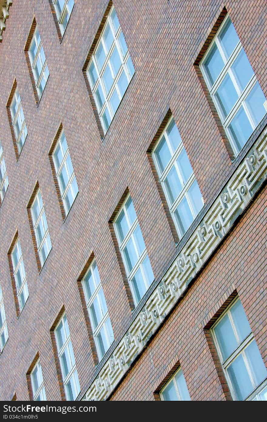 High office building, made of brick. Brown wall, blue windows. High office building, made of brick. Brown wall, blue windows.