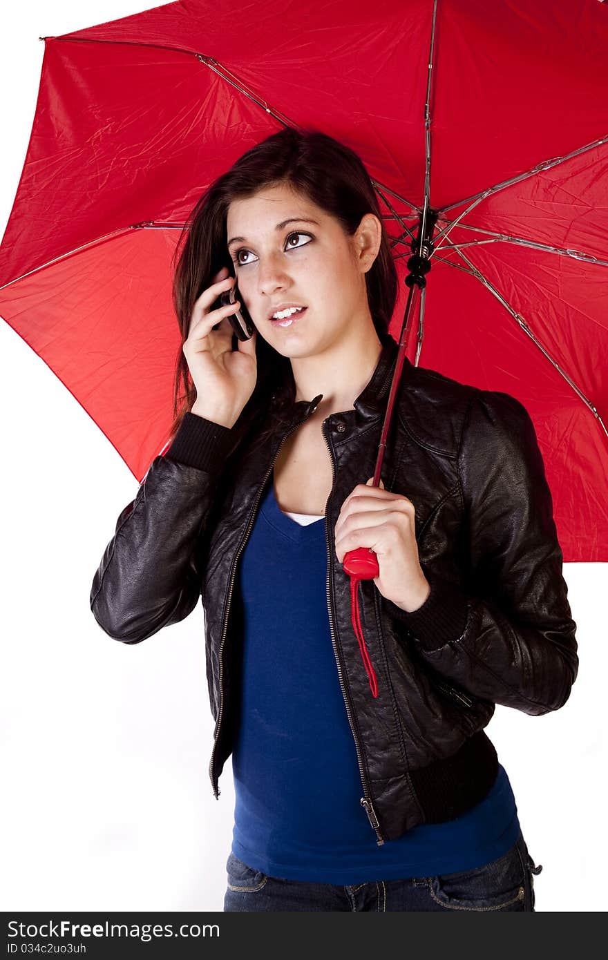 A young woman is standing and holding an umbrella looking up while talking on the phone. A young woman is standing and holding an umbrella looking up while talking on the phone.