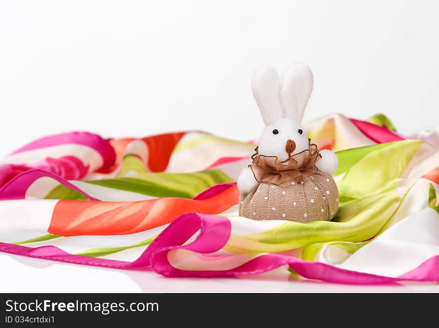 Pretty little hand made rabbit sitting on a bright silk scarf. Pretty little hand made rabbit sitting on a bright silk scarf