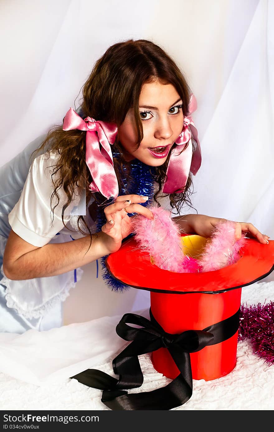 A woman pulls a rabbit out of the red hat for ear