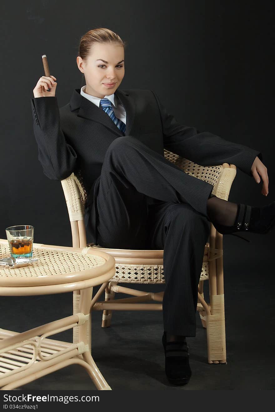 Portrait of the young woman in a man's suit with a cigar. Portrait of the young woman in a man's suit with a cigar