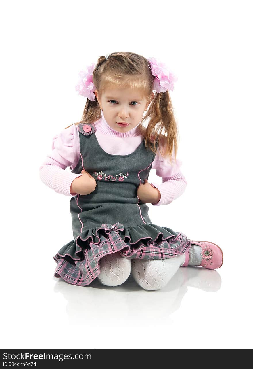 Anger little girl sit on the floor. Studio shot