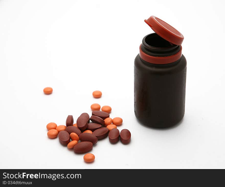 Brown orange pills spilled out of a bottle. Brown orange pills spilled out of a bottle