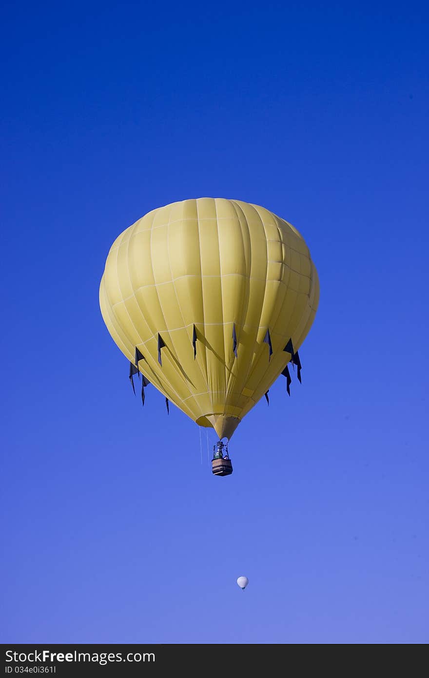 Yellow hot air balloon flying in blue sky