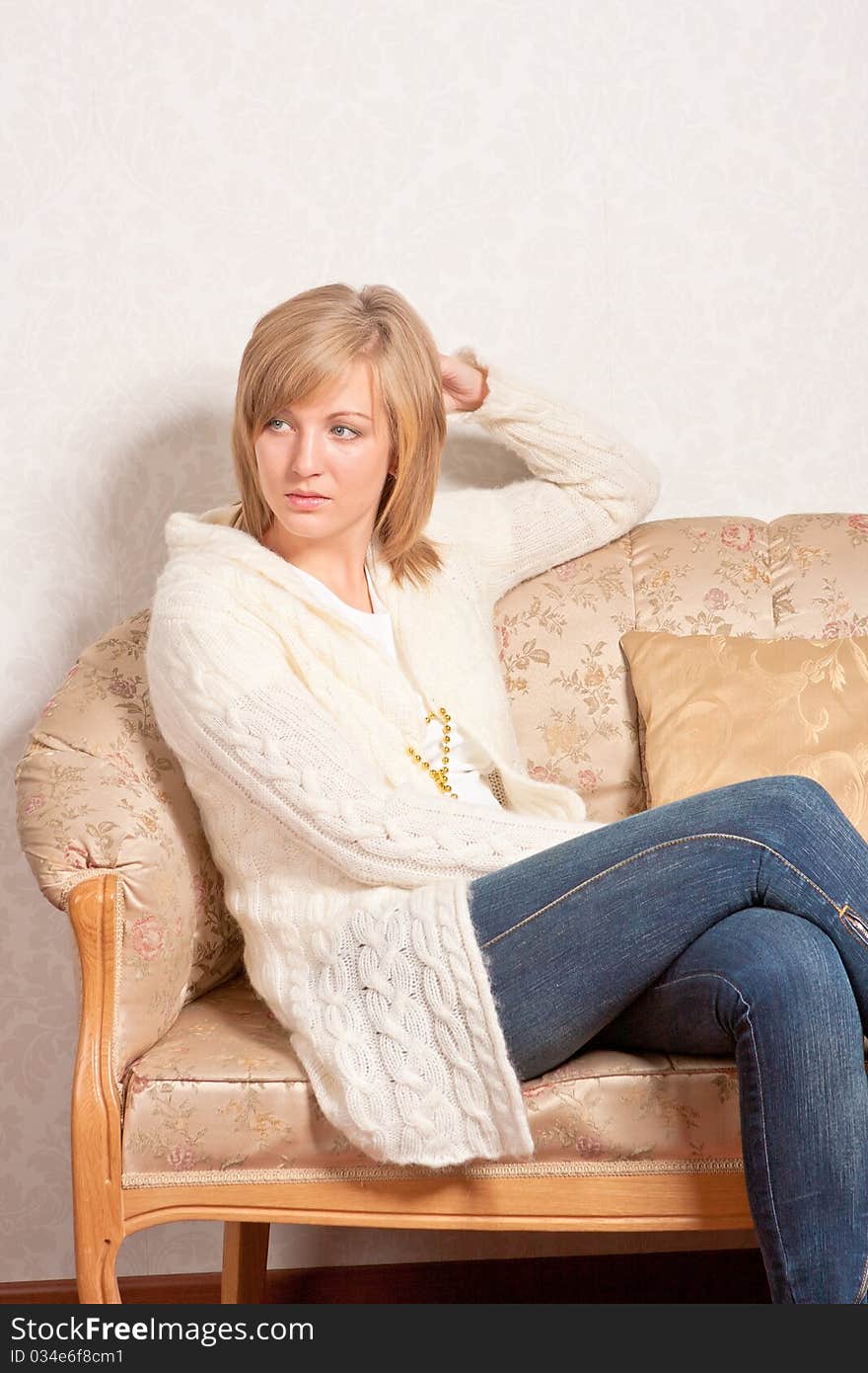 Young Woman Sits On A Sofa