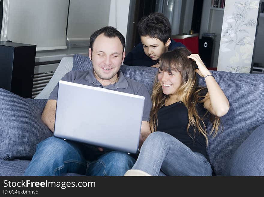 Smiling teenagers and little boy looking at the laptop screen. Smiling teenagers and little boy looking at the laptop screen