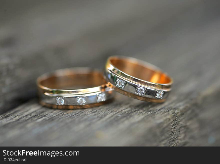 Two golden wedding rings on wooden background