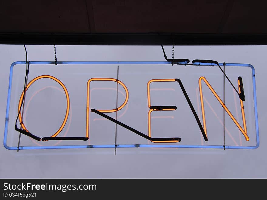 A old style neon open sign with a blue shy.